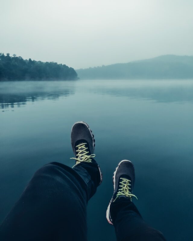 a person standing on a boat with their feet in the water